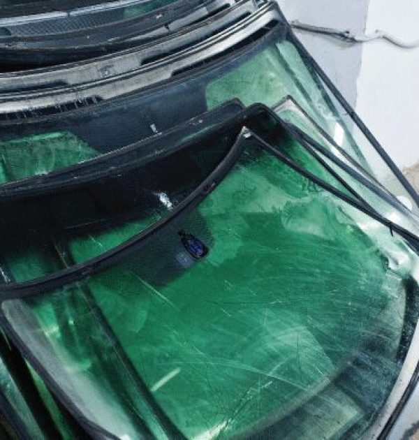 A pile of damaged windshield that have been removed from cars in USA